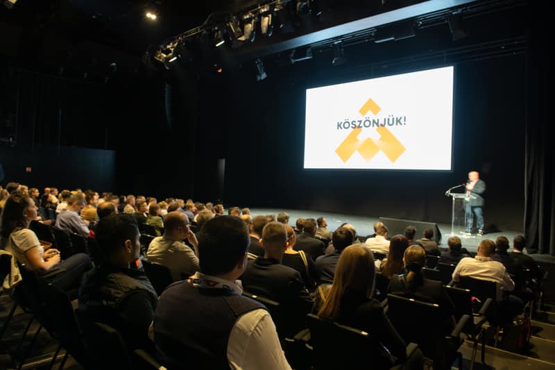 Speaker on stage in front of a packed summit audience